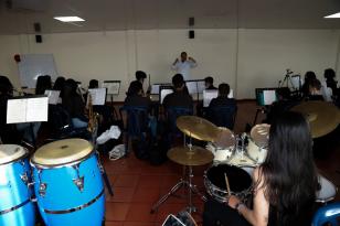 varios niños músicos tocan instrumentos, en primer plano la batería